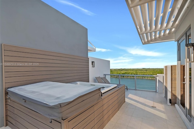 balcony featuring a water view and a hot tub