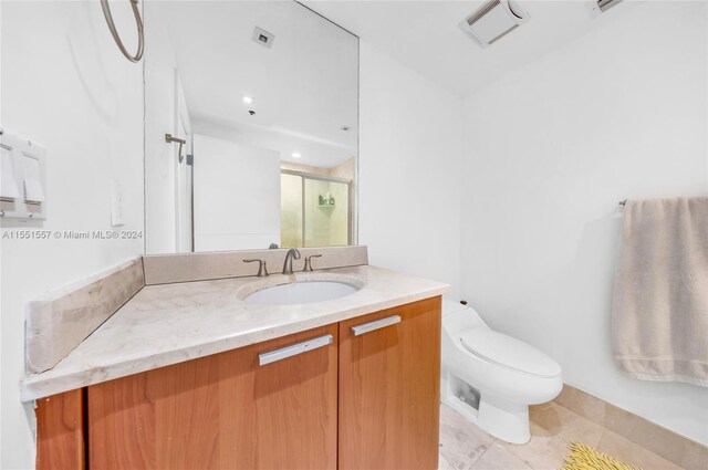 bathroom featuring tile floors, toilet, and vanity