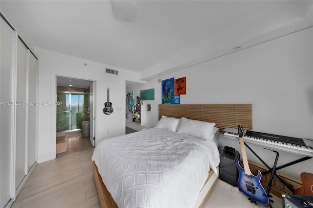 bedroom featuring connected bathroom and light wood-type flooring