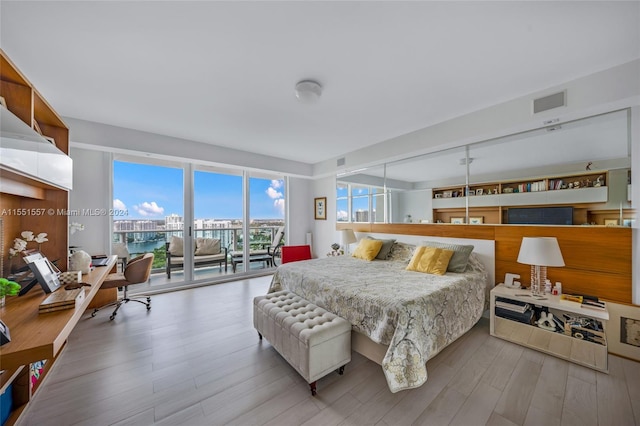 bedroom with access to exterior and light wood-type flooring