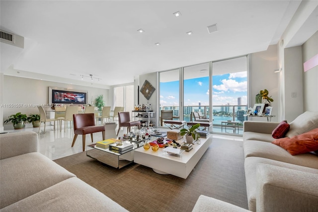 living room featuring a wall of windows and track lighting