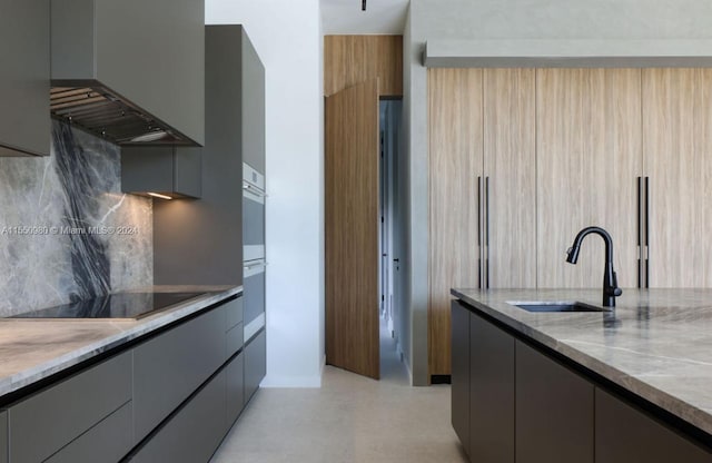 kitchen featuring gray cabinetry, sink, wall chimney exhaust hood, backsplash, and black electric stovetop