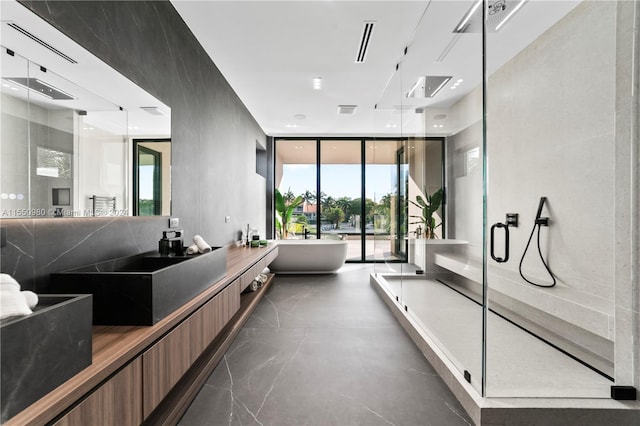 bathroom featuring vanity, expansive windows, and shower with separate bathtub