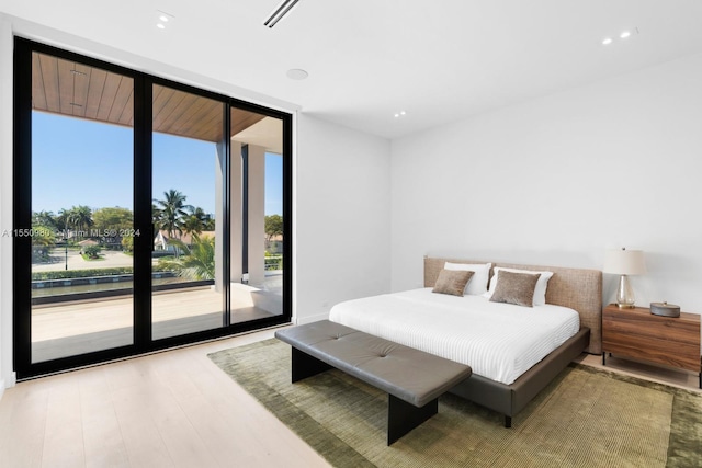 bedroom featuring floor to ceiling windows, access to outside, and hardwood / wood-style flooring