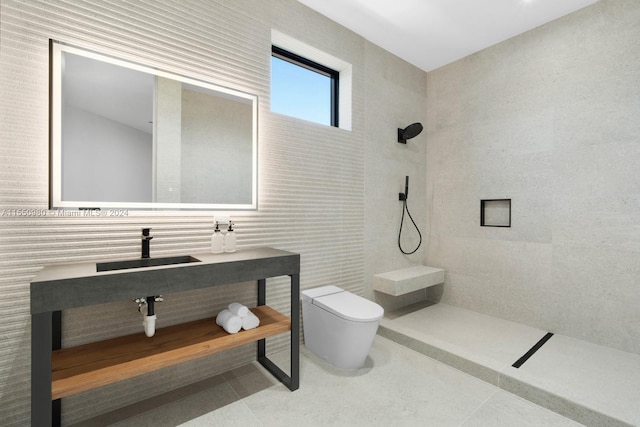 bathroom with sink, tile patterned flooring, toilet, tile walls, and a tile shower