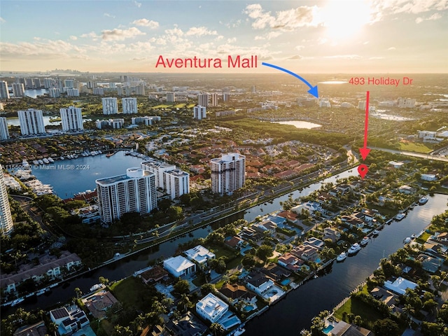 aerial view at dusk featuring a water view