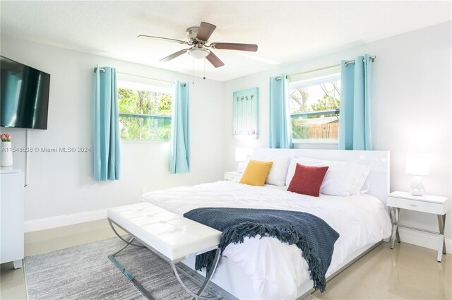 tiled bedroom with multiple windows and ceiling fan