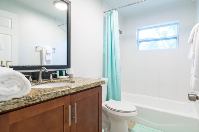 full bathroom with shower / bath combo, toilet, and vanity with extensive cabinet space