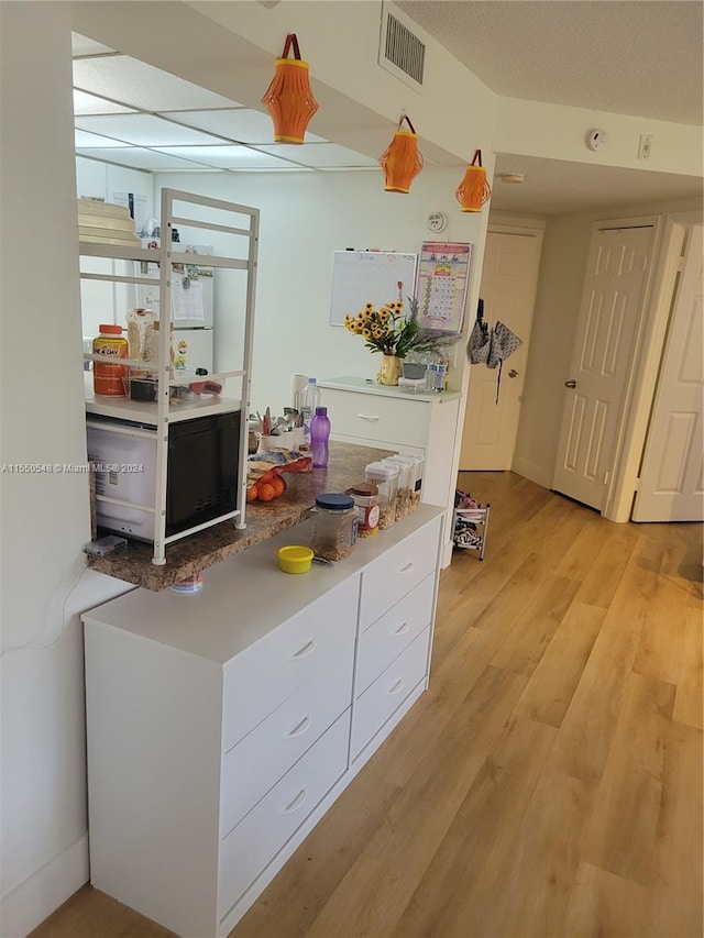 kitchen with light wood-type flooring and white cabinetry