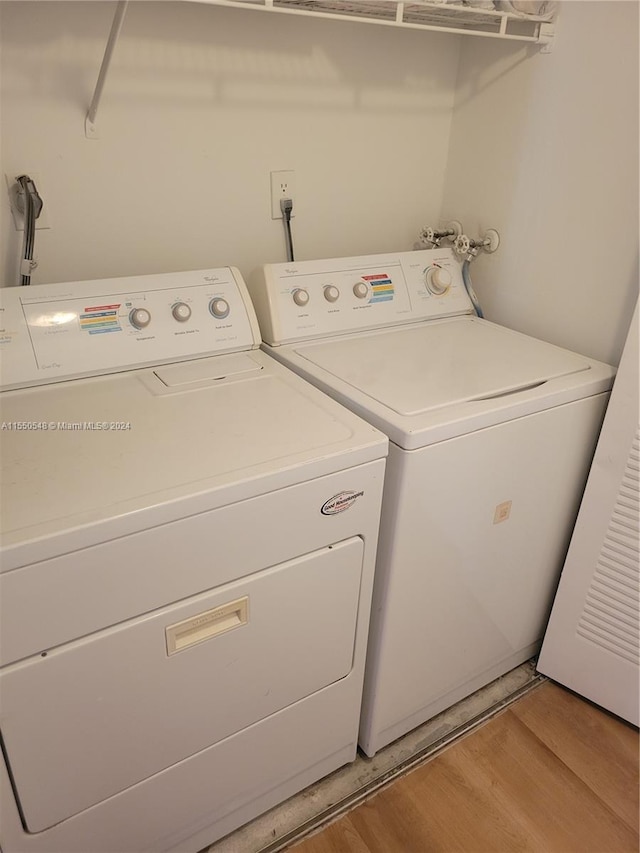 laundry room with washer and clothes dryer and light hardwood / wood-style flooring