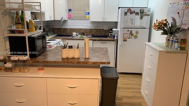 kitchen with white cabinetry, backsplash, white appliances, sink, and light wood-type flooring