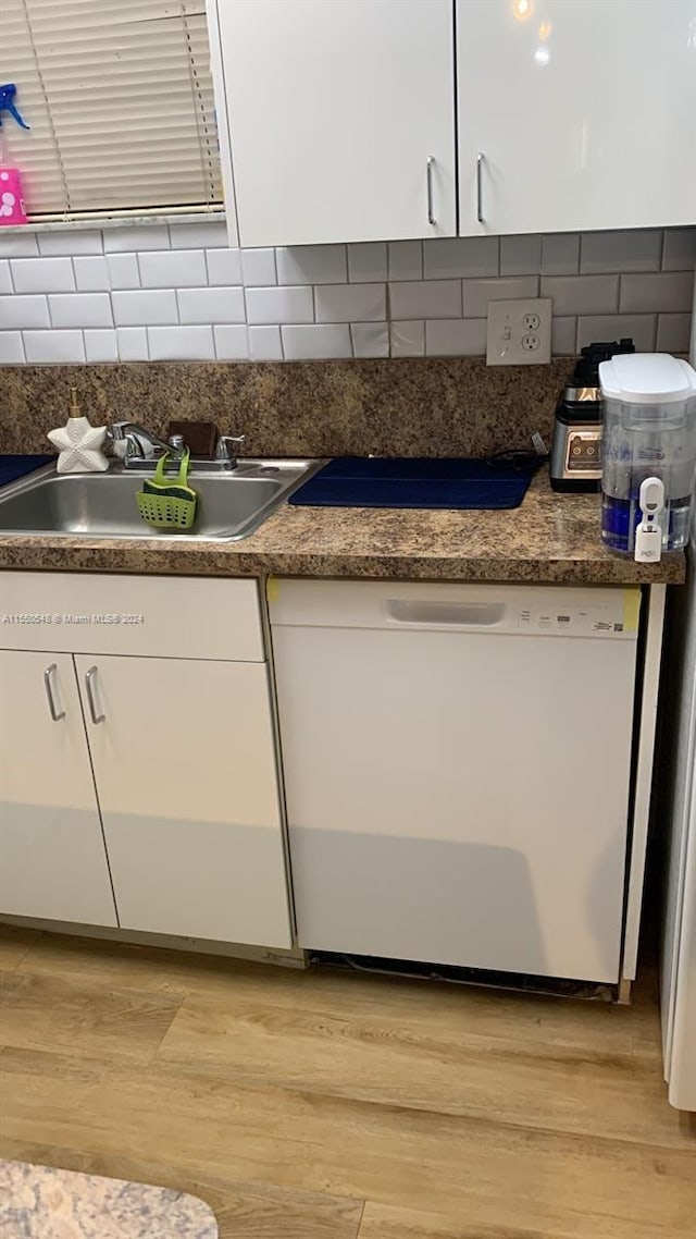 kitchen with light hardwood / wood-style floors, white cabinetry, tasteful backsplash, and sink