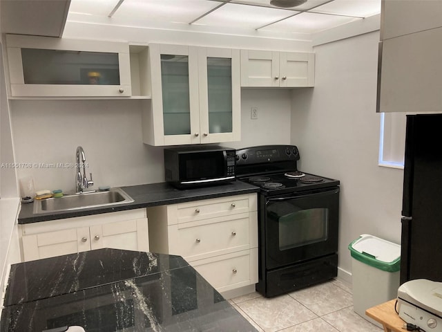 kitchen with white cabinets, sink, light tile floors, and black appliances