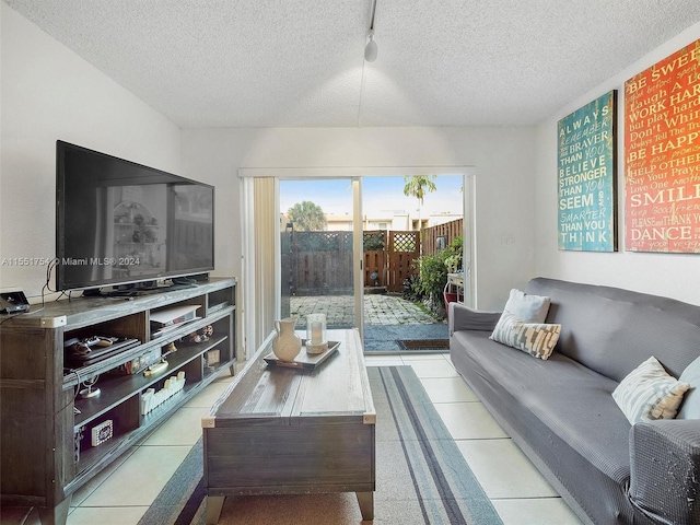 living room with rail lighting, a textured ceiling, and light tile patterned floors