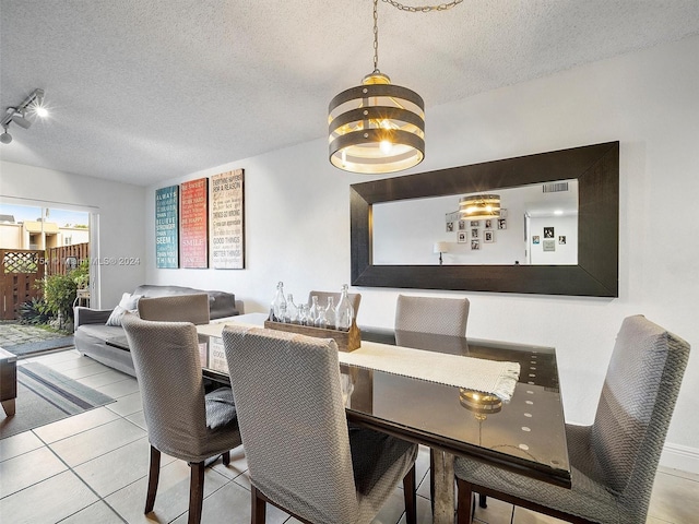 dining room featuring a textured ceiling and tile patterned floors