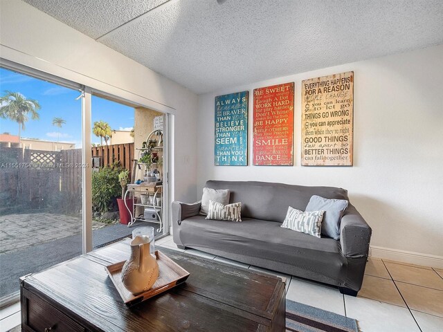 tiled living room featuring a textured ceiling