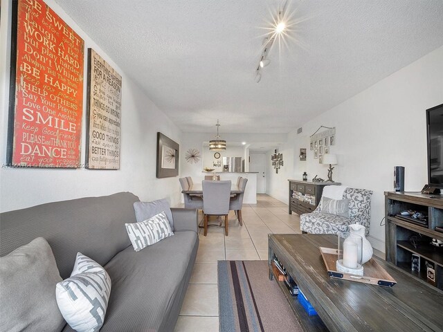 tiled living room featuring a textured ceiling and track lighting