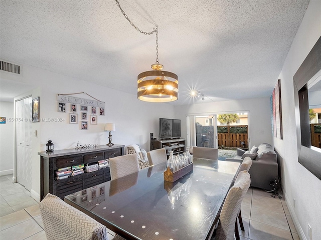 tiled dining room with a textured ceiling