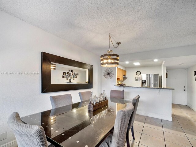 dining area with light tile patterned flooring and a textured ceiling