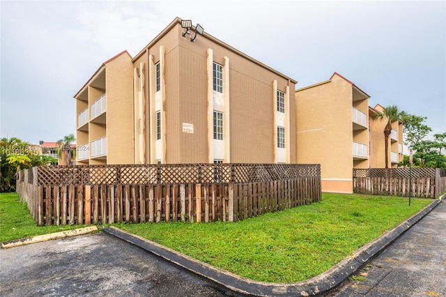 view of property with uncovered parking and fence