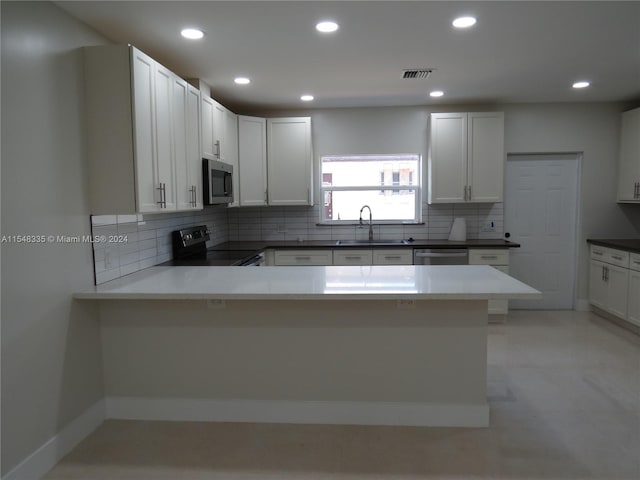 kitchen featuring tasteful backsplash, light tile flooring, white cabinets, and appliances with stainless steel finishes