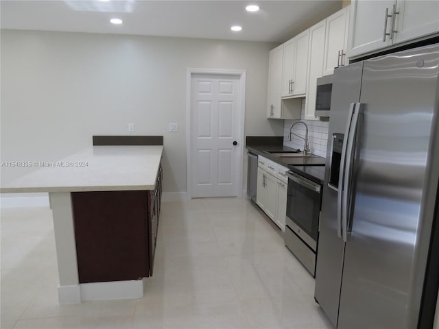 kitchen featuring backsplash, stainless steel appliances, white cabinetry, and light tile floors