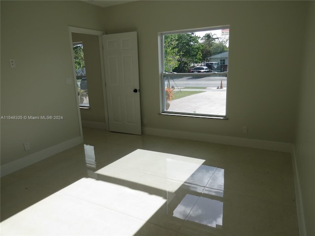 tiled empty room with a healthy amount of sunlight