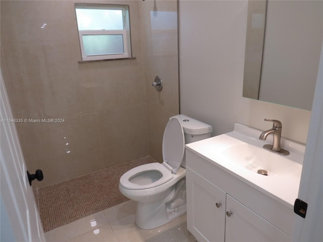 bathroom featuring tile floors, large vanity, toilet, and tiled shower