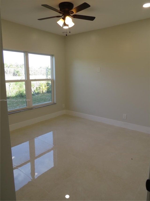 empty room featuring ceiling fan and light tile floors