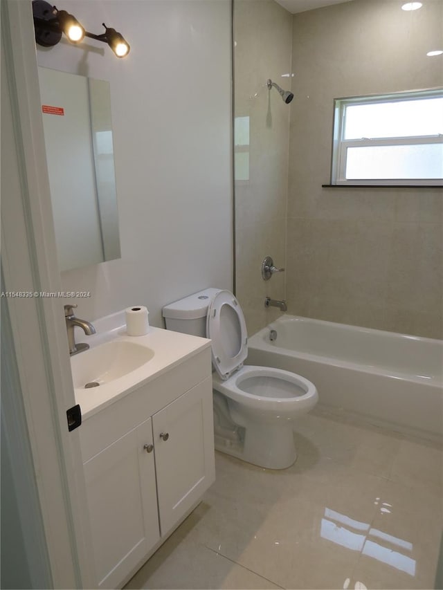 full bathroom featuring toilet, tile floors, tiled shower / bath combo, and vanity