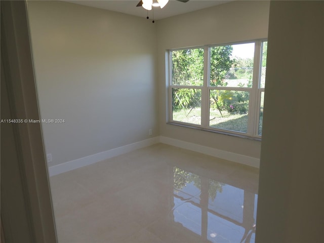 empty room with ceiling fan and a healthy amount of sunlight