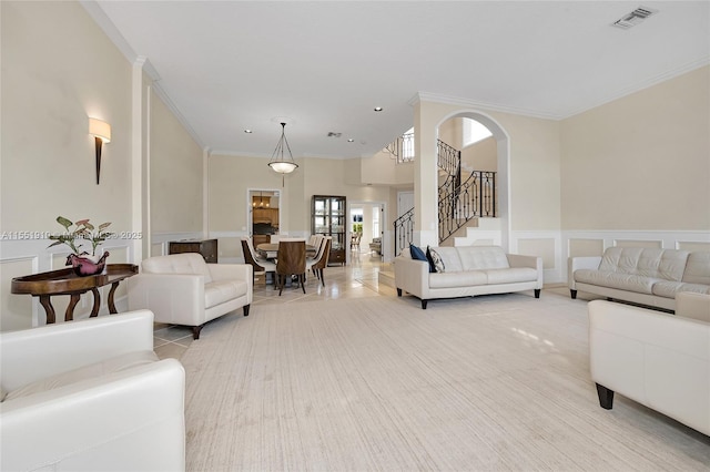 living room featuring light tile patterned floors and crown molding