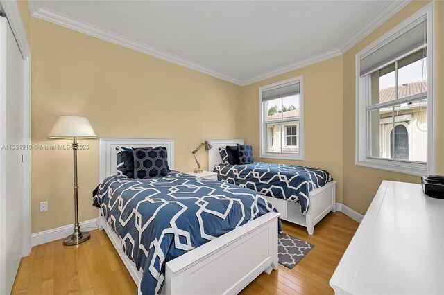 bedroom with hardwood / wood-style floors and ornamental molding