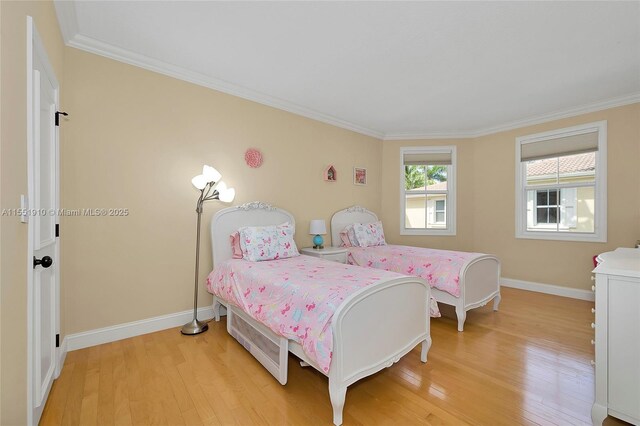 bedroom with crown molding and light hardwood / wood-style flooring