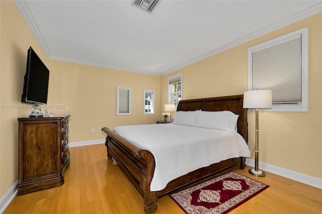 bedroom with light hardwood / wood-style floors and ornamental molding