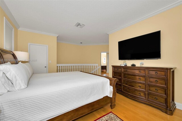 bedroom with crown molding and light hardwood / wood-style flooring