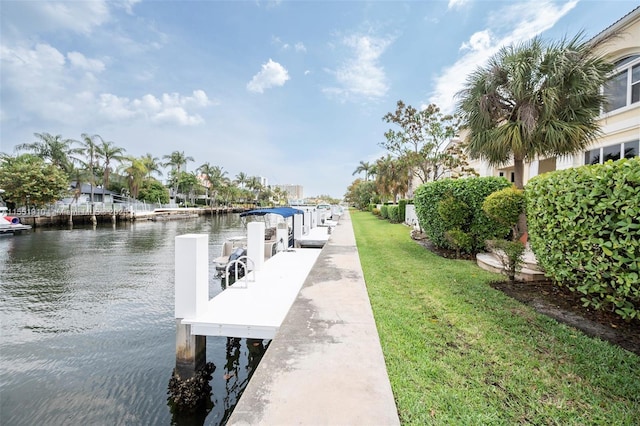 view of dock featuring a water view and a yard