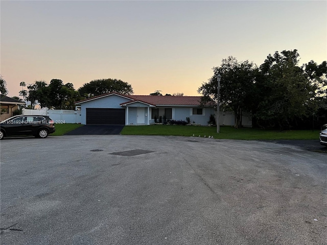 ranch-style home featuring a lawn and a garage