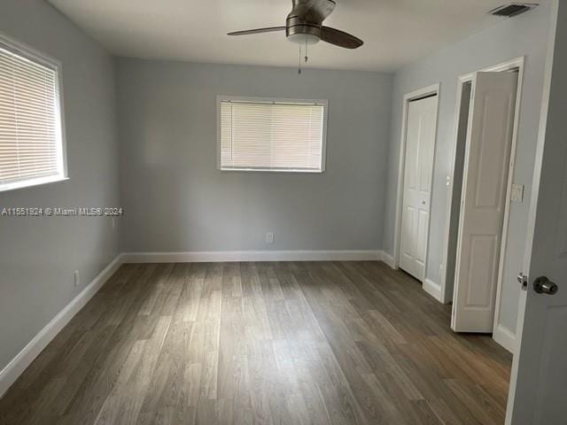 unfurnished bedroom featuring ceiling fan and dark hardwood / wood-style flooring