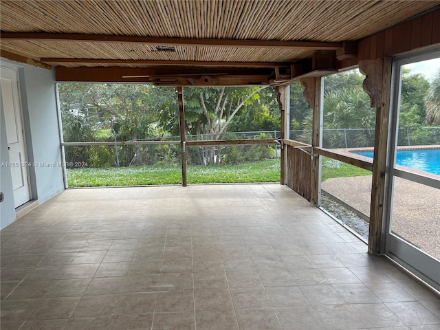 unfurnished sunroom with wood ceiling and beam ceiling