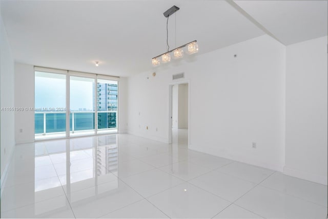 tiled empty room with floor to ceiling windows and a water view