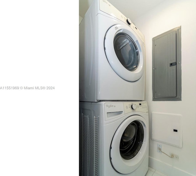 clothes washing area featuring stacked washer and clothes dryer and tile floors