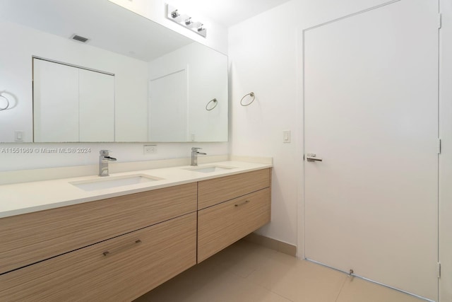 bathroom with vanity with extensive cabinet space, double sink, and tile flooring