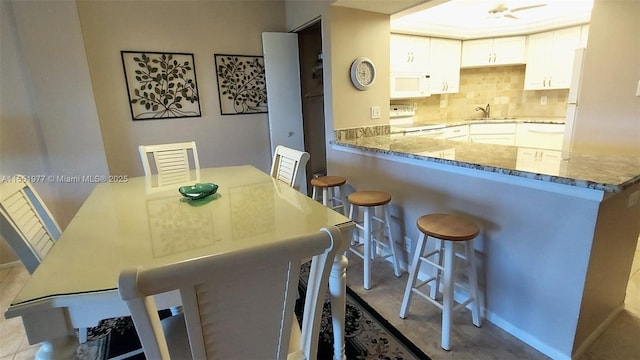 dining space with light tile patterned floors and sink