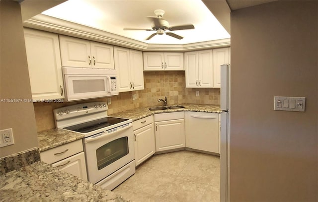 kitchen featuring sink, light stone counters, white appliances, decorative backsplash, and white cabinets