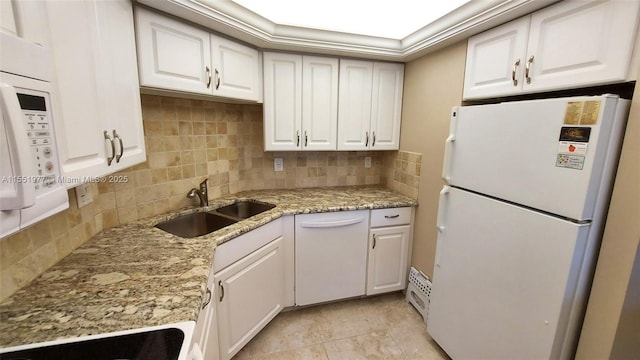 kitchen with sink, white cabinets, decorative backsplash, light stone counters, and white appliances