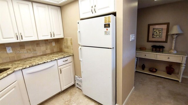 kitchen featuring white appliances, light stone countertops, decorative backsplash, and white cabinets