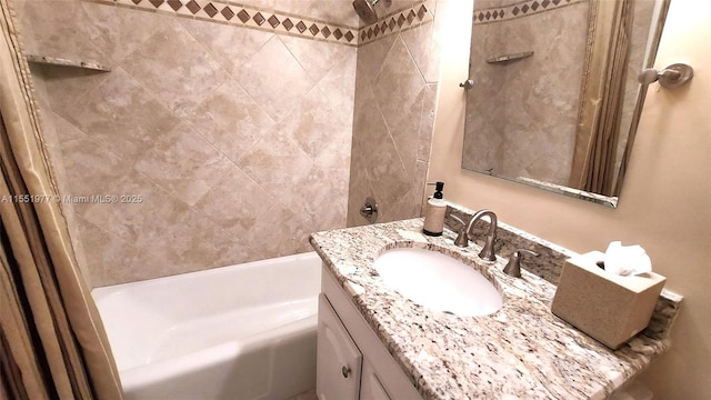 bathroom featuring tiled shower / bath and vanity