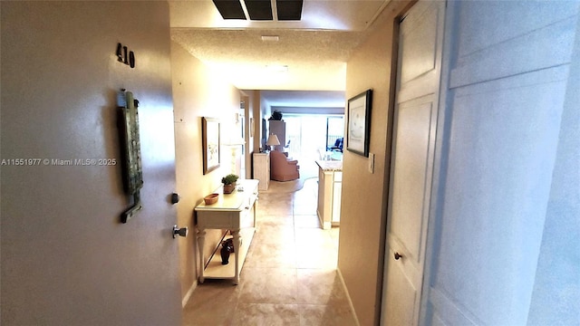 corridor with light tile patterned floors and a textured ceiling