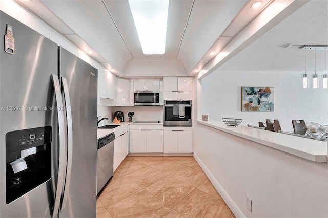 kitchen with sink, light tile floors, hanging light fixtures, stainless steel appliances, and white cabinetry